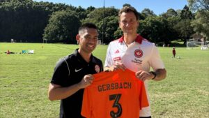Alex Gersbach holding his personalised Balmain DFC number 3 shirt at Waterfront